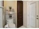 Bathroom featuring a toilet, a built in dark wood cabinet, and a door to the exterior at 1006 Hanging Vine Pt, Longwood, FL 32750