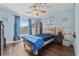 Bright bedroom with blue accents, wood floors, ceiling fan, and playful decor at 12137 Buttonbush Loop, Leesburg, FL 34788