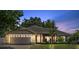 Beautiful single-story home featuring a brick driveway, two-car garage, and mature trees at 12137 Buttonbush Loop, Leesburg, FL 34788