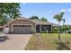 Charming single-story home featuring a brick driveway, two-car garage, and a well-manicured lawn at 12137 Buttonbush Loop, Leesburg, FL 34788