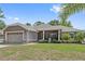 Lovely house with a well-kept lawn, landscaping, and a charming screened porch at 12137 Buttonbush Loop, Leesburg, FL 34788