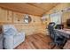 Cozy -shed interior with wood walls, a comfortable recliner, and a functional desk setup at 12137 Buttonbush Loop, Leesburg, FL 34788