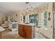 Open kitchen with granite counters, an island with seating, and backyard views at 12137 Buttonbush Loop, Leesburg, FL 34788