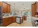 Stylish kitchen with island seating, wooden cabinets, granite countertops, and modern appliances at 12137 Buttonbush Loop, Leesburg, FL 34788