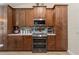 Spacious kitchen featuring rich wood cabinetry, granite counters, and stainless steel appliances at 12137 Buttonbush Loop, Leesburg, FL 34788