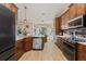 Modern kitchen with wooden cabinets, a central island, and stainless steel appliances at 12137 Buttonbush Loop, Leesburg, FL 34788
