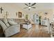 Inviting living room featuring a large sectional sofa, vaulted ceilings, and beautiful wood floors at 12137 Buttonbush Loop, Leesburg, FL 34788