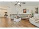 Comfortable living room with a sectional sofa, wood floors, and ample natural light at 12137 Buttonbush Loop, Leesburg, FL 34788