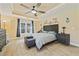 Spacious main bedroom featuring a decorative ceiling, a ceiling fan, and ample natural light at 12137 Buttonbush Loop, Leesburg, FL 34788