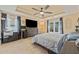 Spacious main bedroom featuring a tray ceiling, a ceiling fan, tile floors, and abundant natural light at 12137 Buttonbush Loop, Leesburg, FL 34788