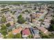 Wide aerial view of neighborhood featuring mature trees, lawns, and houses near a pond at 181 Pinewood Cir, Kissimmee, FL 34743