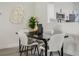 Dining area featuring a modern black table with white chairs, complemented by decorative wall art at 181 Pinewood Cir, Kissimmee, FL 34743