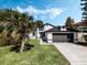 Charming single-story home featuring a well-maintained lawn, mature trees, and a two-car garage at 181 Pinewood Cir, Kissimmee, FL 34743