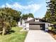 Single-story home with a well-manicured lawn, mature trees, and a convenient two-car garage at 181 Pinewood Cir, Kissimmee, FL 34743