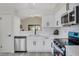 Contemporary kitchen featuring white cabinetry, stainless steel appliances and an open view to the dining area at 181 Pinewood Cir, Kissimmee, FL 34743