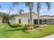 Back of house showing yard and screened patio surrounded by shrubbery at 2244 Silver Lakes N Dr, Lakeland, FL 33810