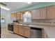 Kitchen with a stainless steel dishwasher, tile backsplash, and warm wood cabinetry at 2244 Silver Lakes N Dr, Lakeland, FL 33810