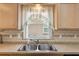 This kitchen features a stainless steel sink, backsplash, and window at 2244 Silver Lakes N Dr, Lakeland, FL 33810