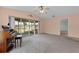 Bright living room with ceiling fan, sliding doors to the lanai, and peaceful water view at 2244 Silver Lakes N Dr, Lakeland, FL 33810
