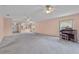 Open-concept living room featuring plush carpeting, view of kitchen, and a classic organ at 2244 Silver Lakes N Dr, Lakeland, FL 33810