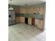 Kitchen featuring tiled flooring, plenty of cabinet space, and stainless-steel refrigerator at 2342 Cilantro Dr, Orlando, FL 32837