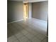 Large, empty living room featuring tiled floors, neutral paint, and a doorway to the hallway at 2342 Cilantro Dr, Orlando, FL 32837