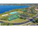 An aerial view of community amenities featuring a pool, clubhouse, lake, and sports courts at 2407 Oakington St, Winter Garden, FL 34787