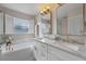 Bright bathroom features dual sinks, a marble countertop, and a soaking tub for a luxurious experience at 2407 Oakington St, Winter Garden, FL 34787