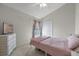 Inviting bedroom with neutral walls, plush bedding, and a window with stylish curtains at 2407 Oakington St, Winter Garden, FL 34787