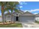 Charming single-story home with a two-car garage, well-maintained lawn, and lovely palm trees at 2407 Oakington St, Winter Garden, FL 34787
