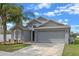 Charming single-story home with a two-car garage, well-maintained lawn, and lovely palm trees at 2407 Oakington St, Winter Garden, FL 34787
