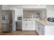 Kitchen with stainless steel appliances, white cabinets, and marble countertops, open to the living room at 2407 Oakington St, Winter Garden, FL 34787