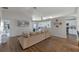 Open living area with wood floors, a large sectional sofa, and a view into the kitchen and other living spaces at 2407 Oakington St, Winter Garden, FL 34787