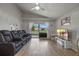 Open-concept living room with entertainment center, Gathering photos, and sliding glass doors to screened lanai at 2407 Oakington St, Winter Garden, FL 34787