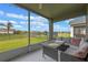 Screened-in patio with seating, offering a serene view of the lush backyard and calming lake at 2407 Oakington St, Winter Garden, FL 34787