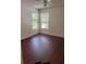 Well-lit bedroom featuring two windows and wood flooring at 2516 Grassy Point Dr # 210, Lake Mary, FL 32746