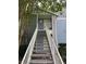 View of the entrance stairs to unit 210 with blue siding and white railings at 2516 Grassy Point Dr # 210, Lake Mary, FL 32746