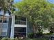 Exterior view of a condominium building with screened balconies and lush landscaping at 2516 Grassy Point Dr # 210, Lake Mary, FL 32746