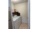 Small laundry room with washer, dryer and storage shelves at 2516 Grassy Point Dr # 210, Lake Mary, FL 32746
