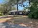 Single-story home with mature landscaping, lush trees, and a well-kept lawn at 261 Deleon Rd, Debary, FL 32713