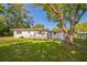 The back of the one-story white house has a large tree that provides shade and an air conditioning unit at 2647 S Myrtle Ave, Sanford, FL 32773