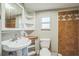 Bathroom features a pedestal sink, tiled shower, and built in storage at 2647 S Myrtle Ave, Sanford, FL 32773
