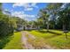 Charming white home with a lush green yard and a palm tree, creating a serene and welcoming ambiance at 2647 S Myrtle Ave, Sanford, FL 32773