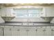 Bright kitchen featuring a double basin sink, window, and white cabinetry at 2647 S Myrtle Ave, Sanford, FL 32773