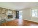Cozy living room with stone fireplace, wood floors, and natural light, perfect for relaxation and entertaining at 2647 S Myrtle Ave, Sanford, FL 32773