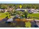 Aerial view of luxury lake house featuring a boat dock and lush landscaping at 2828 Marquesas Ct, Windermere, FL 34786
