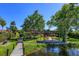 Backyard with wooden dock, a pergola-covered brick patio, and lush green landscaping at 2828 Marquesas Ct, Windermere, FL 34786