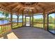 Interior of gazebo with wooden floor, fan, and views of the lake at 2828 Marquesas Ct, Windermere, FL 34786