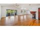 Spacious living room with a fireplace, hardwood floors, and access to a screened-in porch with lake views at 2828 Marquesas Ct, Windermere, FL 34786