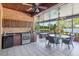 The screened in brick patio features an outdoor kitchen and dining area with beautiful lake views at 2828 Marquesas Ct, Windermere, FL 34786